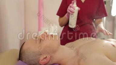 美容师在乳房脱毛后处理男人的皮肤。 甘蔗