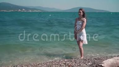 一个穿着白色海滩礼服的女孩，沿着<strong>海滨</strong>散步。 一个光着脚的漂亮女孩沿着<strong>海滨</strong>散步。