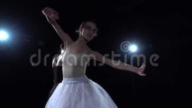 完美的<strong>芭蕾舞</strong>演员穿着白色和黑色的<strong>芭蕾舞</strong>裙在舞蹈中旋转。 快，慢<strong>动作</strong>。