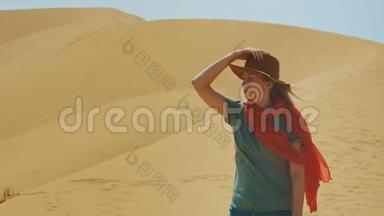 一个戴着<strong>帽子</strong>的年轻女旅行者在沙漠中的<strong>沙滩</strong>上。 肖像，中东旅行的概念