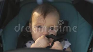 特写：可爱的女孩看着坐在蓝色婴儿车里的镜头微笑-家庭价值观<strong>暖色</strong>夏景