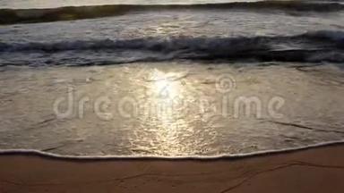 阳光在海水中反射，在沙质的海岸上留下波浪