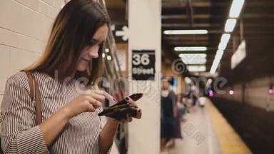 美丽的年轻女子在地铁列车<strong>平台</strong>上持有<strong>智能</strong>手机和钱包购买购物在线应用程序。