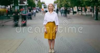 成熟的女人站在城市繁华的街道上看镜头