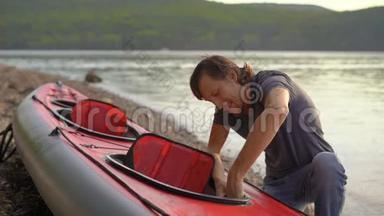 年轻人把皮艇充气，准备在湖或海中划水。 慢镜头