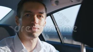 商人和司机在车里旅行的肖像。 穿白衬衫的年轻人<strong>坐出租车</strong>