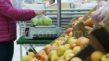 女士在超市用苹果称重包