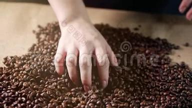 咖啡豆。 手散落的咖啡豆.. 女人`手摸咖啡豆。 咖啡蝇烤谷物品质。