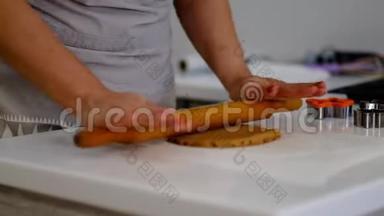 厨师为准备饼干切面团。 女面包师把面团切成叶子形状。 上班时的糖果师