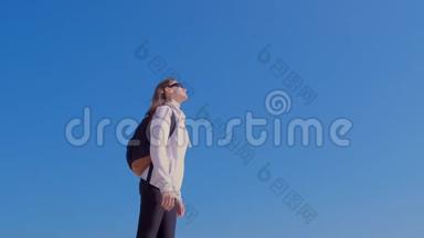 女旅行者带着背包享受大自然<strong>的</strong>蓝天背景度假。