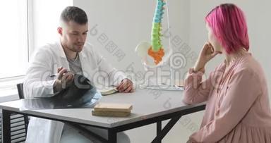 医生正在和一位有着粉红色头发的病人谈论她的脊柱问题，显示脊柱受影响的部位
