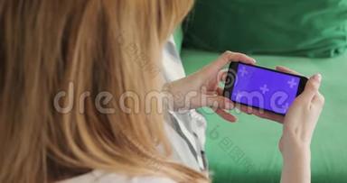 女士正在使用手机与色度键<strong>紫色水</strong>平屏幕，手机和手特写。