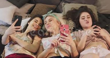 穿着智能手机的漂亮少女们，一边躺在床上，一边吃着口香糖和口香糖