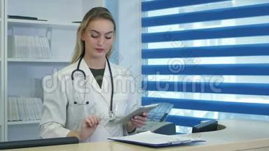 在<strong>医院前台</strong>使用平板电脑和电话的漂亮护士