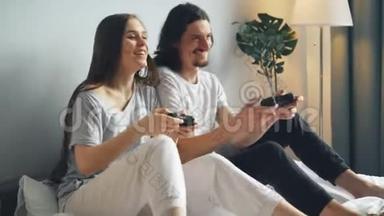 男人和女人一<strong>起坐</strong>在床上玩电子游戏