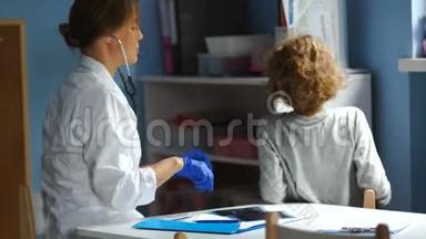 儿科医生在接待处为学生检查。用听诊器从后面听<strong>肺部</strong>