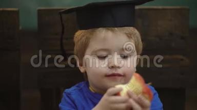 带着<strong>毕业</strong>帽和苹果的男孩。 学习观念。 穿制服的学童。 老师和学生。 回到学校