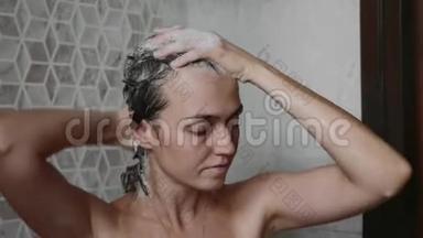年轻的女人正在用洗发水洗头，用闭着眼睛洗澡。