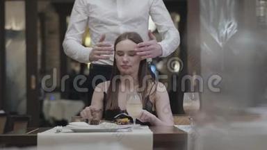 一个美丽的年轻女孩在咖啡馆或餐馆吃饭的肖像。 一个长着胡子的男人或丈夫走到后面，<strong>关上门</strong>