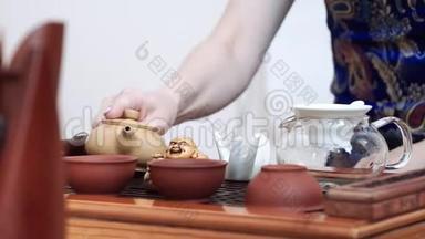 在木桌上有一套供中国茶道用的茶具，杯子，茶壶和盖湾