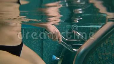 一名年轻女子在水下水上运动自行车和水上跑步机上做运动的慢速镜头。 水上运动