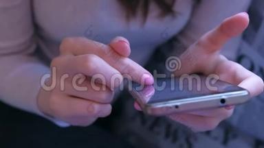 女人用手指在智能手机上翻书，双手特写。