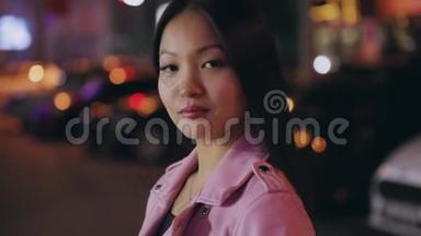 一幅美丽的亚洲女人在夜晚城市转脸看镜头的画像