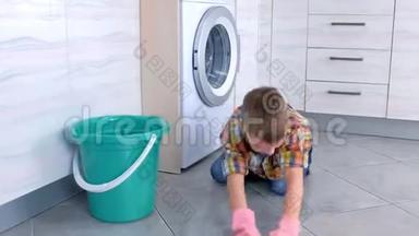 穿橡胶<strong>手套</strong>的男孩在<strong>厨房</strong>里洗地板，玩布。 儿童`的家庭责任。