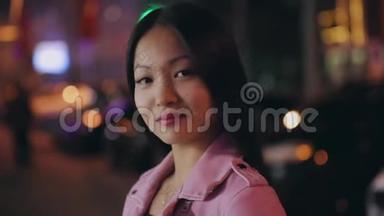 一幅美丽的亚洲女人在夜晚<strong>城市</strong>转脸<strong>看镜头</strong>的画像