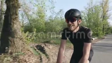 快乐快乐的<strong>骑车人</strong>在公园骑自行车时微笑。 骑自行车的人戴着黑色的头盔和太阳镜。 自行车的概念。 奴隶