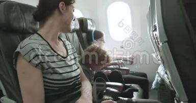 女人和两个孩子坐在飞机上，坐在颠簸的出租车上穿过<strong>停机坪</strong>