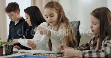 有魅力的孩子和他们成熟的母亲一起做作业，一起度过美好时光的画像