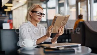 漂亮的成熟商务女士在咖啡厅午休时阅<strong>读书籍</strong>