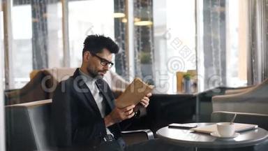 一个人坐在咖啡馆里读书翻页