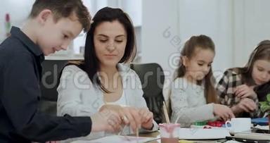 三个孩子<strong>放学</strong>后在一张大桌子上的客厅里做作业，他们的成熟和成熟