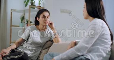 两个成熟的姐妹一起在沙发上亲密交谈，他们在宽敞的客厅里集中交谈