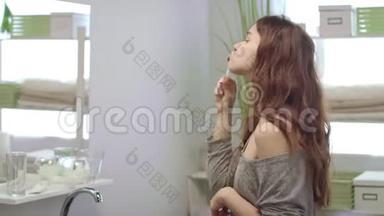 在浴室里，年轻女子用刷子清洁牙齿，摆着镜子