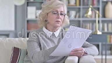 老年妇女阅读沙发文件