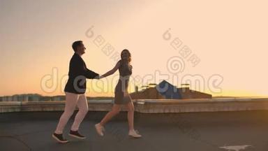 年轻夫妇牵着手走着，女人牵着男朋友在屋顶的建筑日落，POV概念