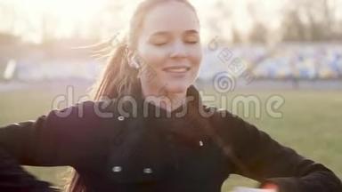 在一个<strong>阳光</strong>明媚的<strong>秋日</strong>，戴着无线耳机的年轻女孩进行健身运动。