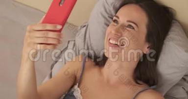 在<strong>床上玩手机</strong>视频聊天的女人