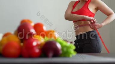女运动员在厨房里测量腰部
