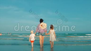 幸福的母亲和女儿和儿子在日落时在海滩上玩和玩。 动作缓慢。 幸福家庭