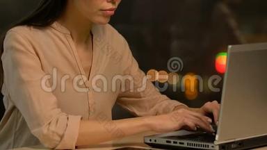 疲惫的年轻女士在笔记本电脑上打字，感到手腕疼痛，摩擦它，最后期限