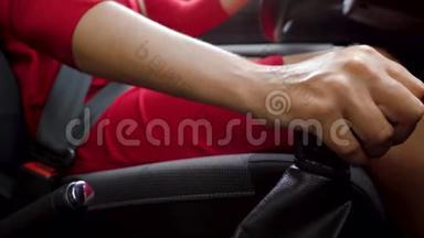 女人坐在车里，在变速箱上换<strong>挡</strong>。 系安全带