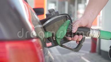 用燃油手工加注汽车。 在加油站用汽油或汽油给汽车加油的人。 伸出一只手