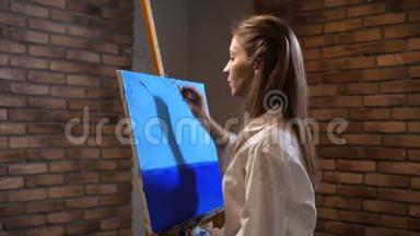 新手艺术家描绘风景。 调色板刀女孩做一个美丽的蓝天。 4K慢慢