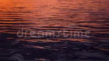 美丽的粉红色涟漪水域。 在水中反射日落光线。 水的背景.. 它的纹理