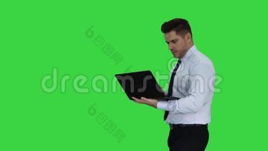 商人按下播放按钮开始或启动项目或演示在笔记本电脑上的绿色屏幕，铬键。
