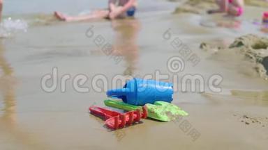 儿童玩具在热带沙滩，家庭度假。 塑料铲子玩具，供孩子在海边玩。 海滩概念